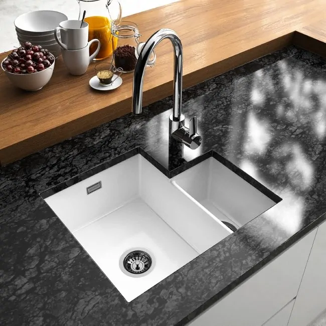 Undermount stainless steel sink fitted beneath a quartz worktop, showing the seamless flush junction with no visible rim